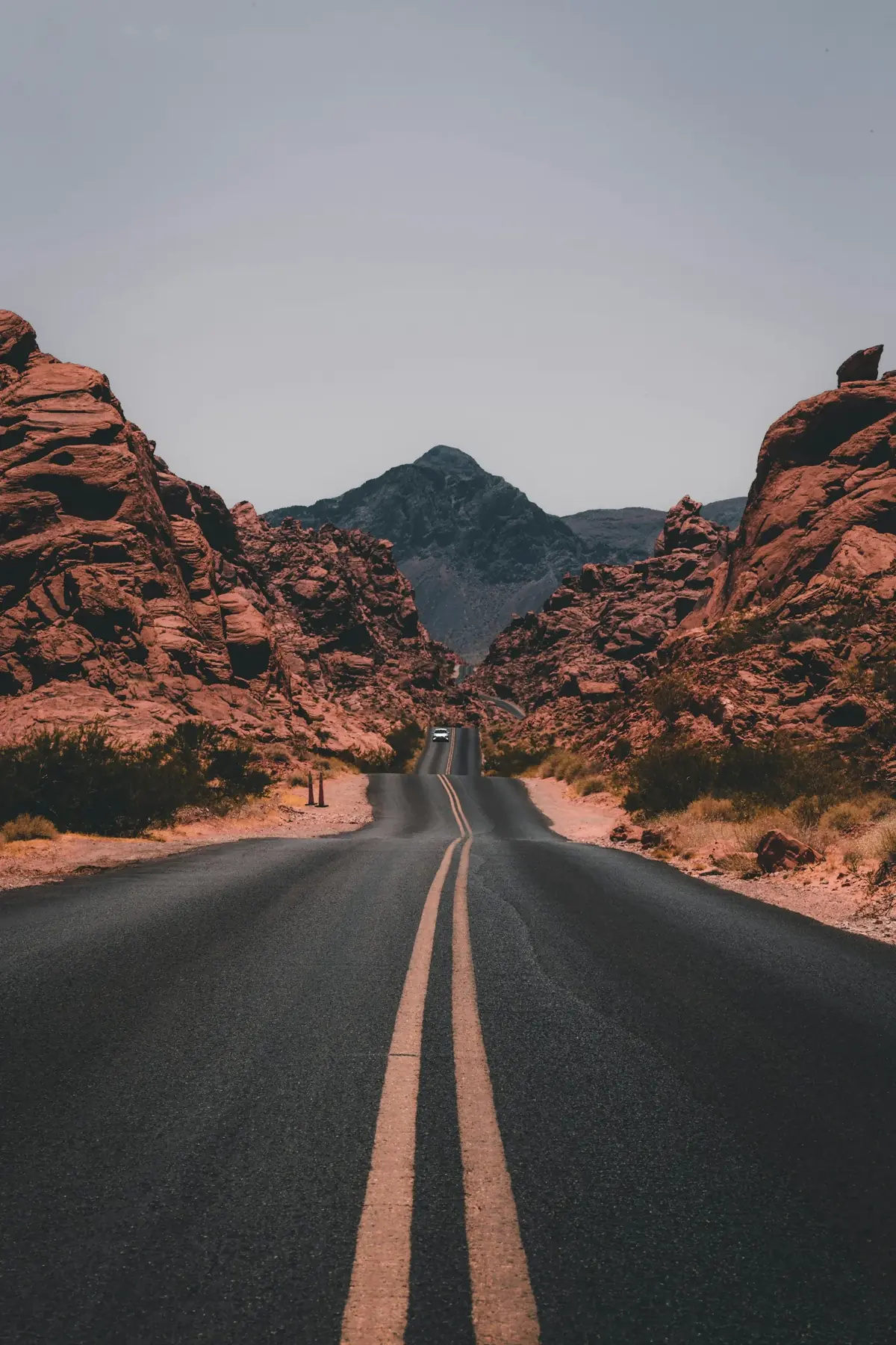 An empty road running between red rock hills